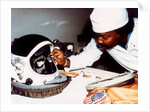 Technician installing eye-glasses in helmet by NASA