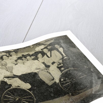 Group portrait of ten women and a man huddled in a carriage in a studio by Anonymous