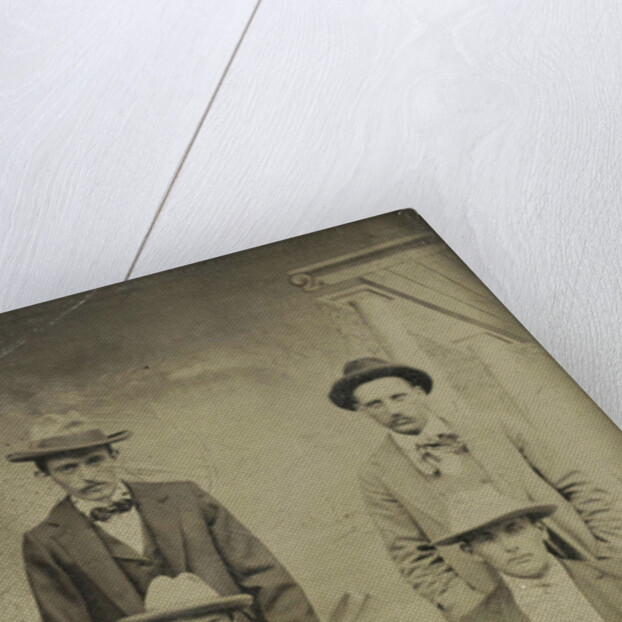 Portrait of four men sitting and standing in front of a painted backdrop, architecture by Anonymous
