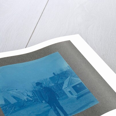 Man standing on a clothesline in a garden, USA by Anonymous