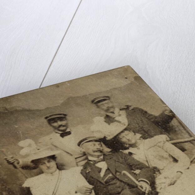 Group portrait of three men and two women in visible cheerful mood, standing and sitting in front of a painted backdrop showing a mountain castle by Anonymous