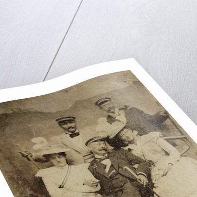 Group portrait of three men and two women in visible cheerful mood, standing and sitting in front of a painted backdrop showing a mountain castle by Anonymous