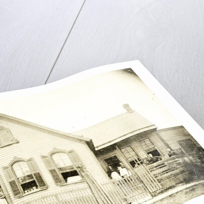 View of a wooden house with about nine people before or standing in doorways, United States by Anonymous