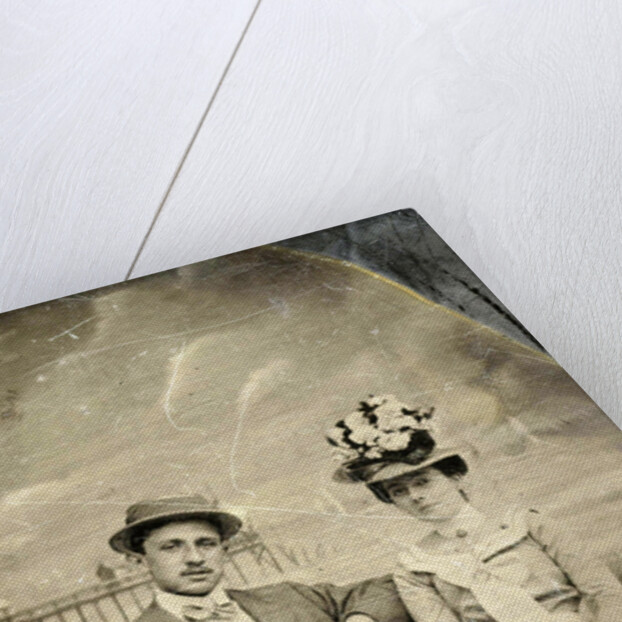 Portrait of a man and woman sitting in front of a painted backdrop (beach, sea and pier) by Anonymous