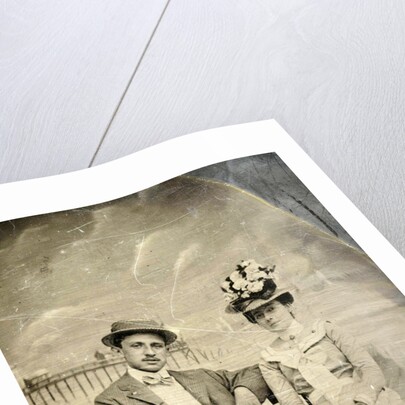 Portrait of a man and woman sitting in front of a painted backdrop (beach, sea and pier) by Anonymous