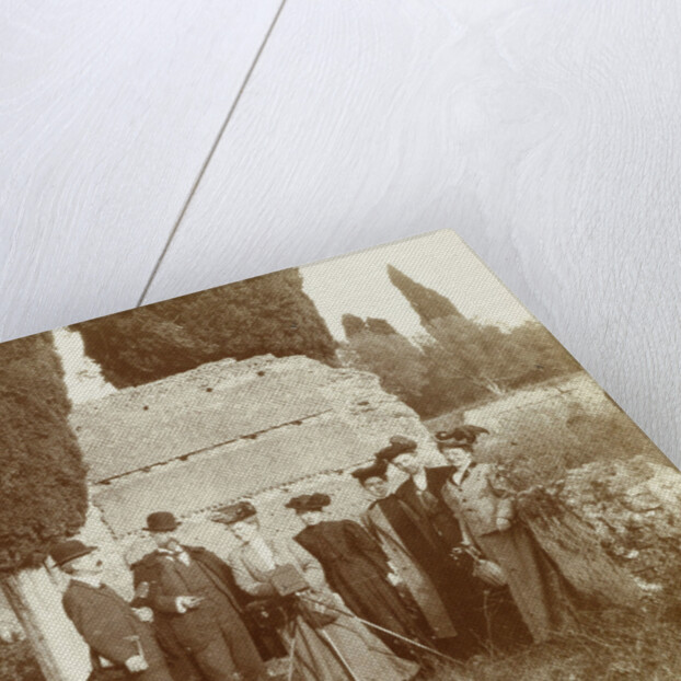 Group portrait of five women (one of whom is behind a camera) and two men for a ruin in Italy or France by Anonymous
