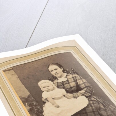 Portrait of a woman in a plaid dress with a baby on lap by E. Steffen