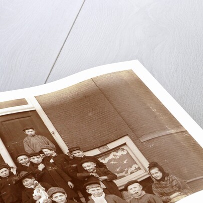 Group of children posing on stairs for entrance doors by Anonymous