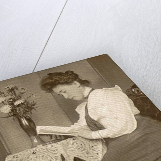 Book Reading woman sitting at a table with a vase of flowers by Anonymous