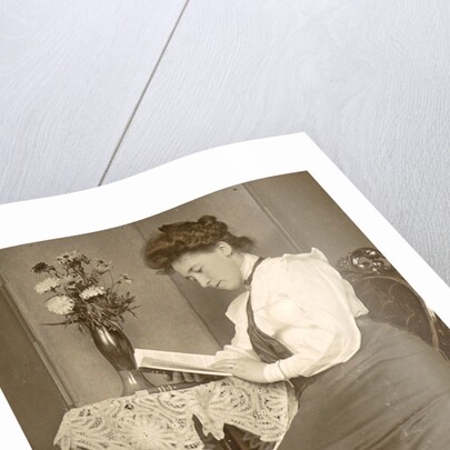 Book Reading woman sitting at a table with a vase of flowers by Anonymous