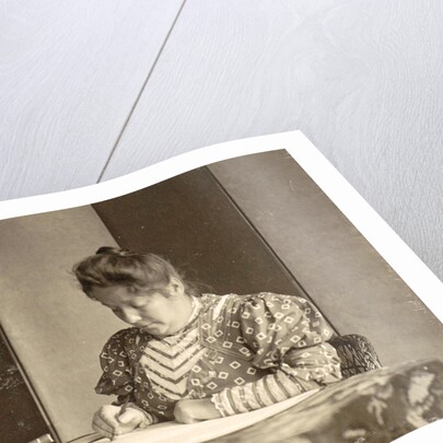 woman writing at a table by Anonymous