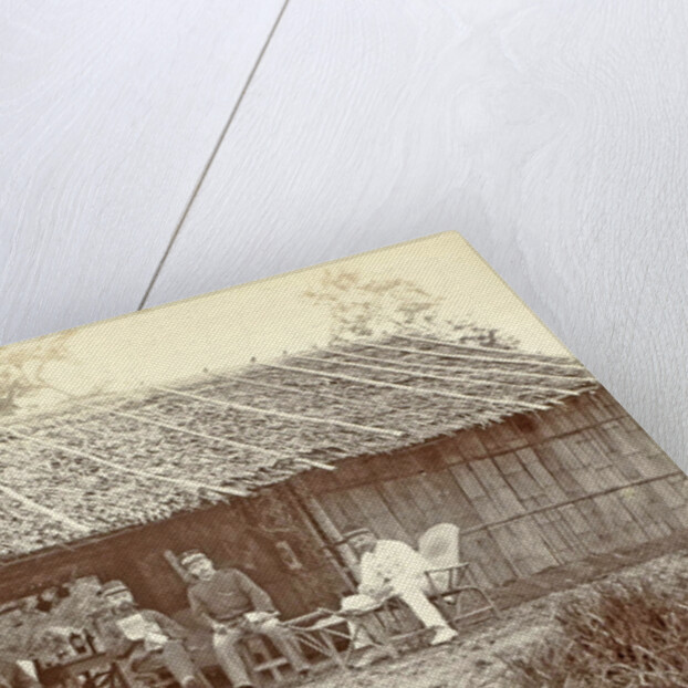 Dutch soldiers sitting in front of a wooden house in the Dutch East Indies by Anonymous