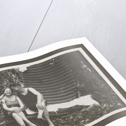 Man and a woman in swimwear on a bench in a forest by Anonymous