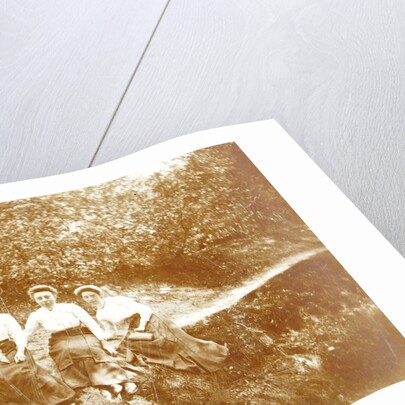 Three women sitting in a forest near a path by Anonymous