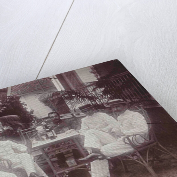 Group of men at the table in front of the porch is verved by Indian man by Anonymous