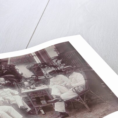 Group of men at the table in front of the porch is verved by Indian man by Anonymous