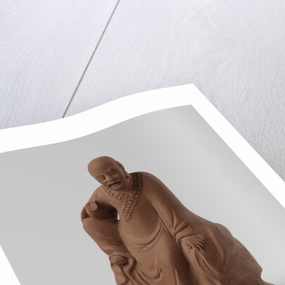 Man figure with raised right leg on rocky pedestal. Red stoneware. by Anonymous