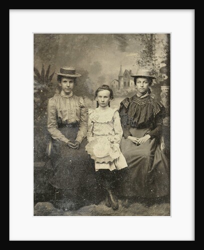Portrait of two women and a girl sitting in a studio with painted backdrop by Anonymous