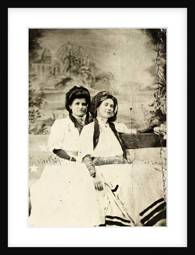 Portrait of two women sitting on a bench in front of a painted backdrop (chapel or church (?) In a lake), in the left part of the American flag by Anonymous