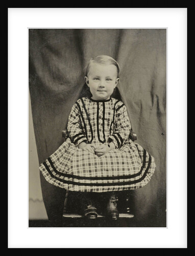 Portrait of a child sitting on a chair in a studio setting by Anonymous
