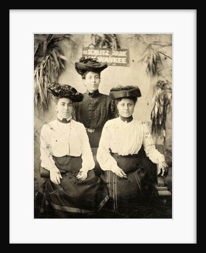 Portrait of three women standing and sitting in a studio setting, and behind them a sign that read AT SCHLITZ PARK MILWAUKEE by Anonymous