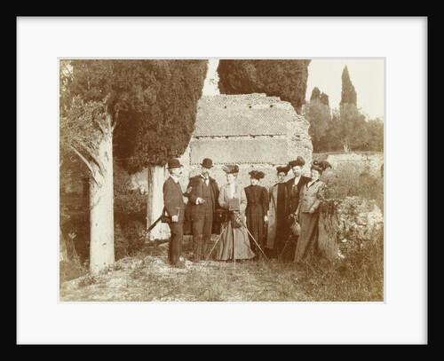 Group portrait of five women (one of whom is behind a camera) and two men for a ruin in Italy or France by Anonymous