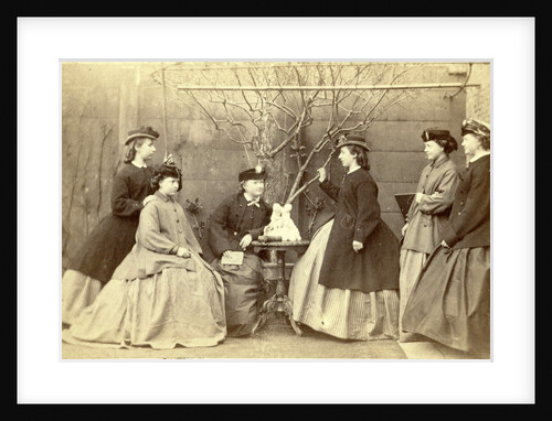 Group portrait of six young women in garden round table with sculpture, hats and coats by L. de Koningh