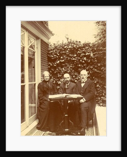Two men and a woman sitting at home with a book on the table by Anonymous