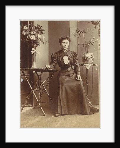 Woman sitting in a greenhouse at tables with flowers and plants by Anonymous