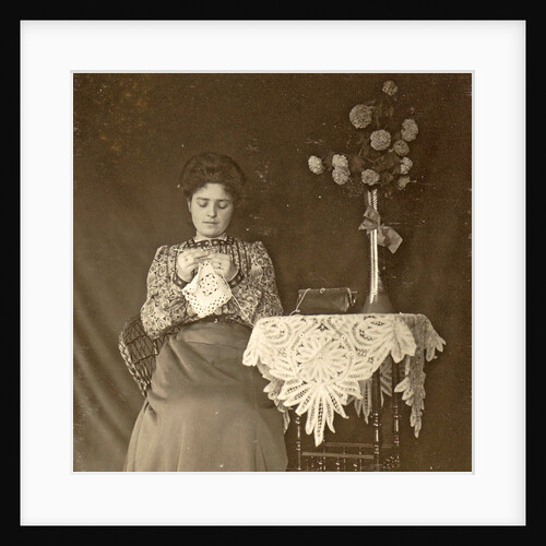 Female working at a table with tablecloth and flowers by Anonymous