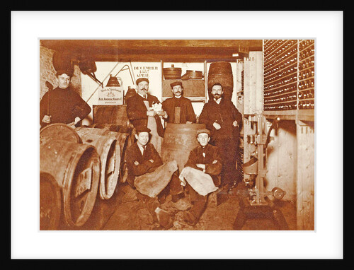 Group portrait of a brewer and servants between barrels and bottles by Anonymous