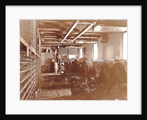 Interior of a brewery: wooden barrels and bottles on shelves by Anonymous
