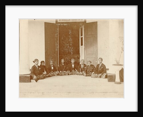 Eight Indian young men sat on the floor at an entrance in the Dutch East Indies by Anonymous