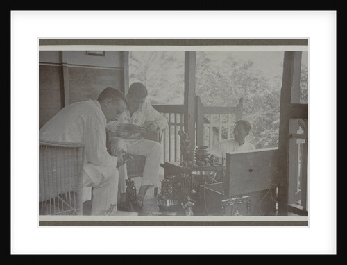 Two men view the wares of an Indian vendor by Anonymous