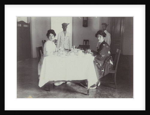 Group portrait of young women at the table with servants in the Dutch East Indies, indonesia by Anonymous