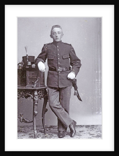 Studio portrait of man in uniform with dresser by J.L.T. Huijsen
