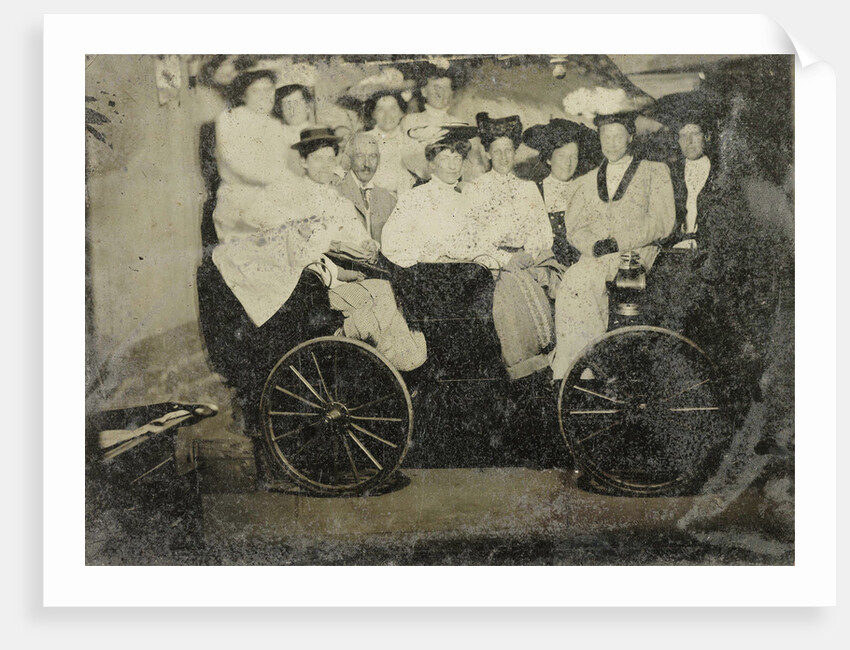 Group portrait of ten women and a man huddled in a carriage in a studio by Anonymous