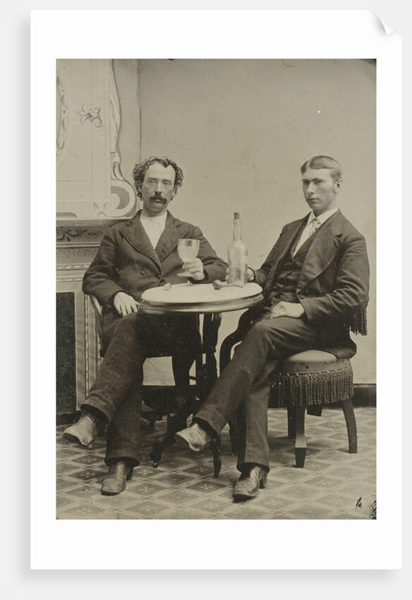 Portrait of two men sitting at the table in a studio, with a bottle and a glass, an imitation salon decor by Anonymous