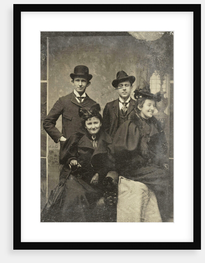 Portrait of two men and two women, one of whom looks away laughing, standing and sitting in front of a painted backdrop by Anonymous