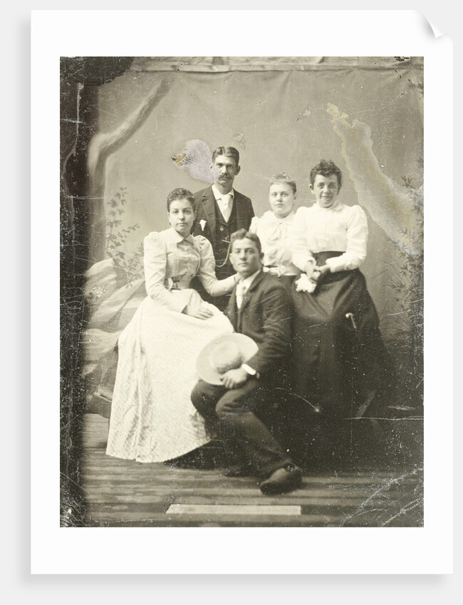Group portrait of two men and three women, standing and sitting in front of a painted backdrop, tree, rocks by Anonymous