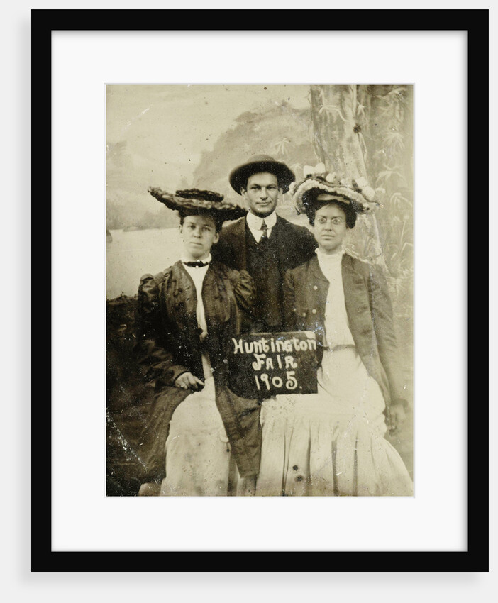 Portrait of a man and two women in front of a painted backdrop (tree, lake and mountains) and a sign that read 'Huntington FAIR 1905 by Anonymous