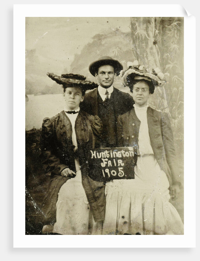 Portrait of a man and two women in front of a painted backdrop (tree, lake and mountains) and a sign that read 'Huntington FAIR 1905 by Anonymous