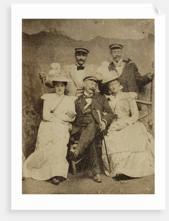 Group portrait of three men and two women in visible cheerful mood, standing and sitting in front of a painted backdrop showing a mountain castle by Anonymous