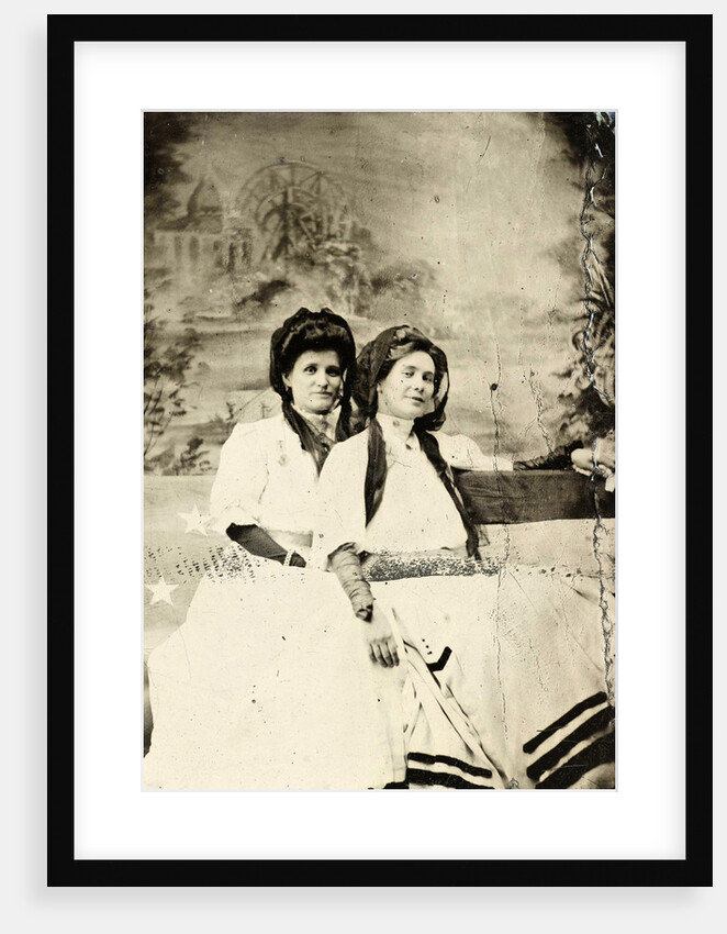 Portrait of two women sitting on a bench in front of a painted backdrop (chapel or church (?) In a lake), in the left part of the American flag by Anonymous