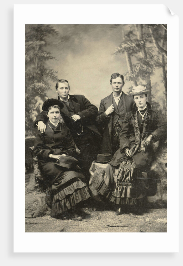 Two men and two women standing and sitting in front of a painted backdrop (forest) by Anonymous