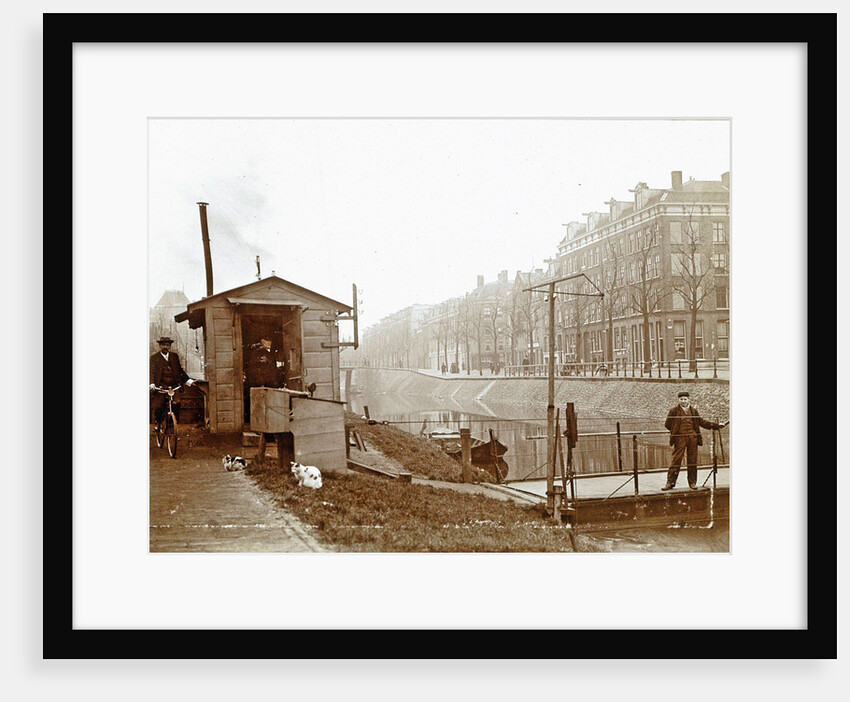 Men, presumably workers, and two cats at a jetty and a guardhouse along a canal by Anonymous