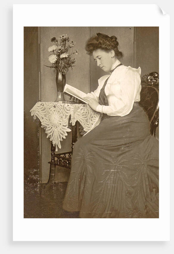 Book Reading woman sitting at a table with a vase of flowers by Anonymous