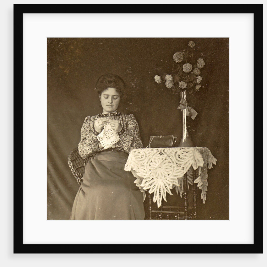 Female working at a table with tablecloth and flowers by Anonymous