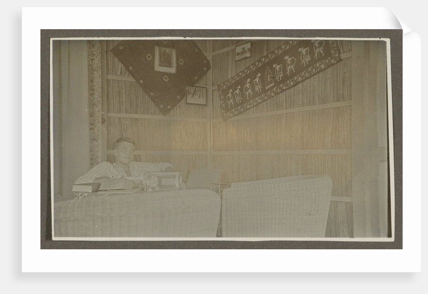 Man sitting at a table by Anonymous