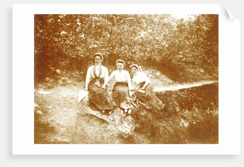 Three women sitting in a forest near a path by Anonymous